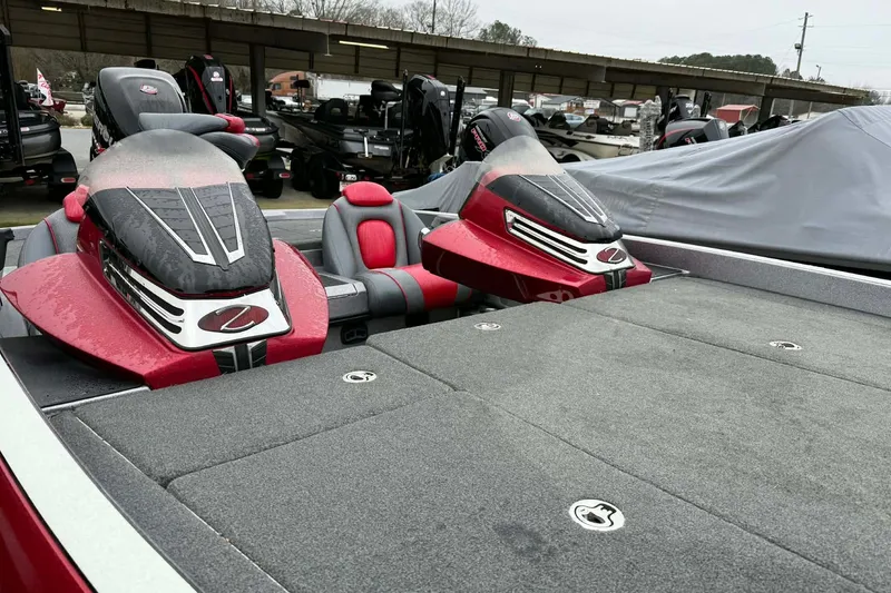 Slide: The Image of 2015 Ranger Z518 Comanche boat with red and gray seating, parked in a marina. - 10
