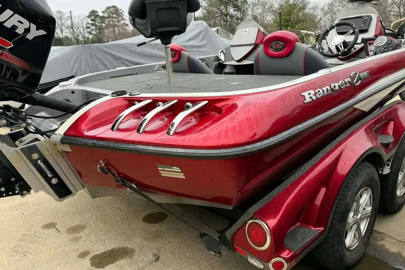 Slide: The Image of 2015 Ranger Z518 Comanche boat, red exterior, parked on trailer, rear view. - 4
