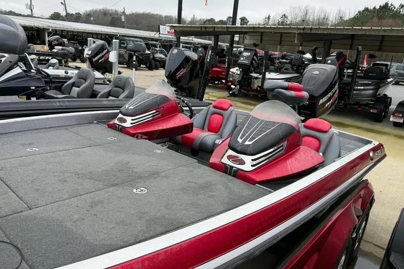 Slide: The Image of 2015 Ranger Z518 Comanche boat with red and gray seating, parked among other boats. - 5