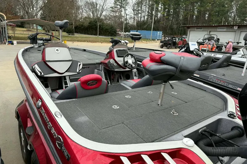 Slide: The Image of 2015 Ranger Z518 Comanche boat with red and gray interior, parked outdoors. - 6