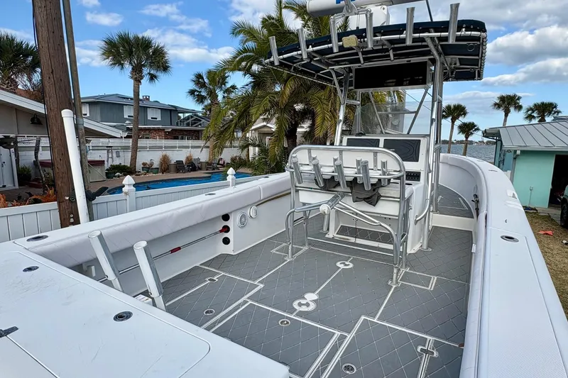 Slide: The Image of 2006 Bluewater 2850 CC boat with spacious deck, palm trees, and waterfront view. - 10