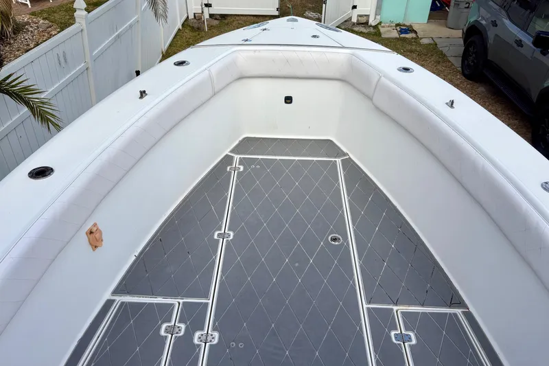 Slide: The Image of 2006 Bluewater 2850 CC boat interior with cushioned seating and diamond-patterned flooring. - 11