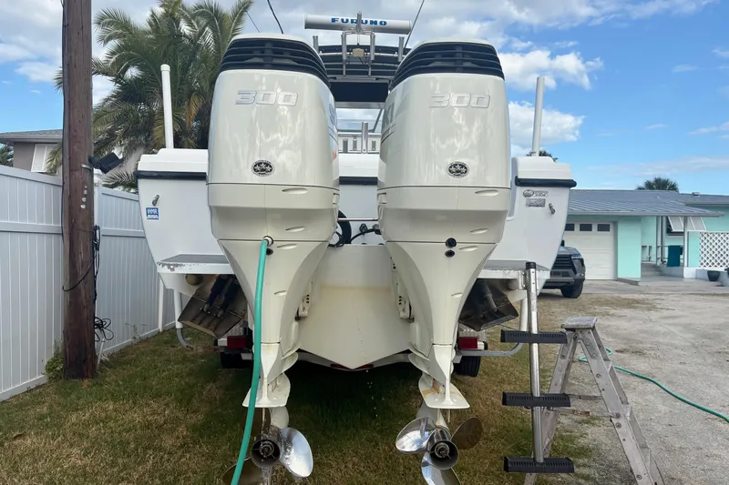 Slide: The Image of 2006 Bluewater 2850 CC boat with dual 300 horsepower engines, parked outdoors. - 13