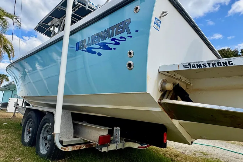 Slide: The Image of 2006 Bluewater 2850 CC boat on trailer, side view with logo visible. - 3