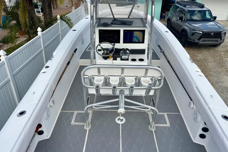 Slide: The Image of 2006 Bluewater 2850 CC boat interior with helm, rod holders, and navigation screens. - 6