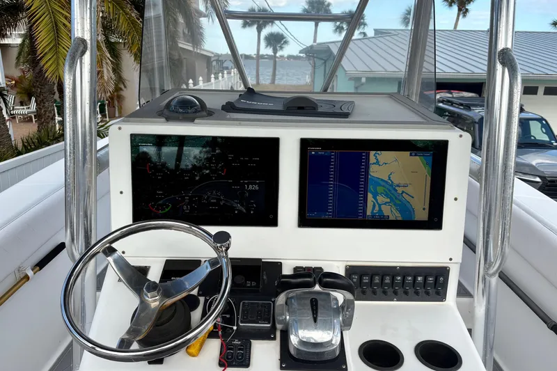 Slide: The Image of 2006 Bluewater 2850 CC boat dashboard with navigation screens and steering wheel. - 7
