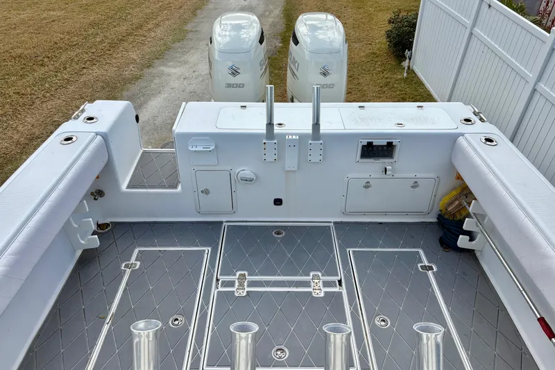 Slide: The Image of 2006 Bluewater 2850 CC boat deck with dual Suzuki 300 engines, spacious seating, and storage compartments. - 9