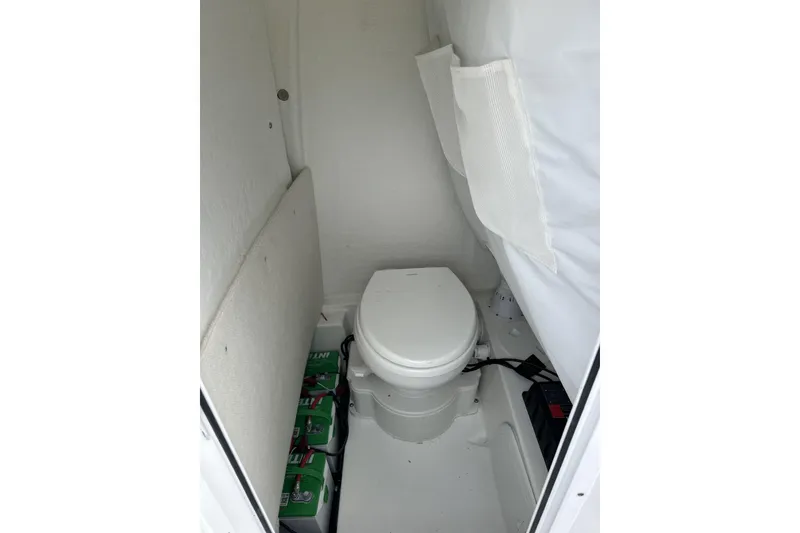 Slide: The Image of Interior of 2026 Sea Hunt Ultra 245 SE boat with compact marine toilet. - 15
