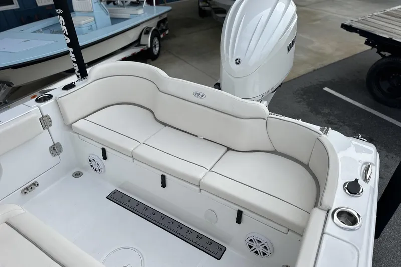 Slide: The Image of 2026 Sea Hunt Ultra 245 SE boat interior with white seating and Yamaha engine. - 2