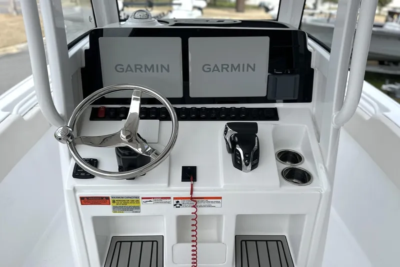 Slide: The Image of 2026 Sea Hunt Ultra 245 SE boat console with Garmin displays and steering wheel. - 4