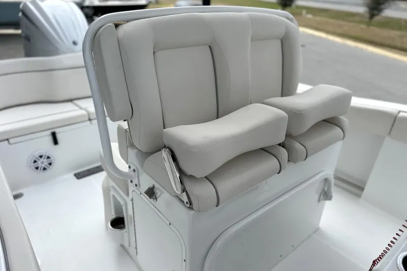 Slide: The Image of 2026 Sea Hunt Ultra 245 SE boat seating with cushioned armrests and storage compartment. - 5