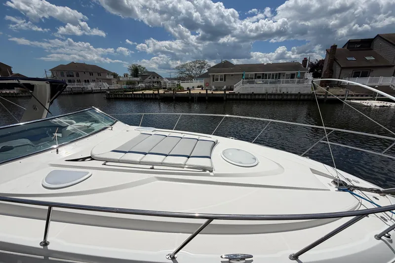 Slide: The Image of 2006 Monterey 350 Sport Yacht docked by waterfront homes under a cloudy sky. - 21
