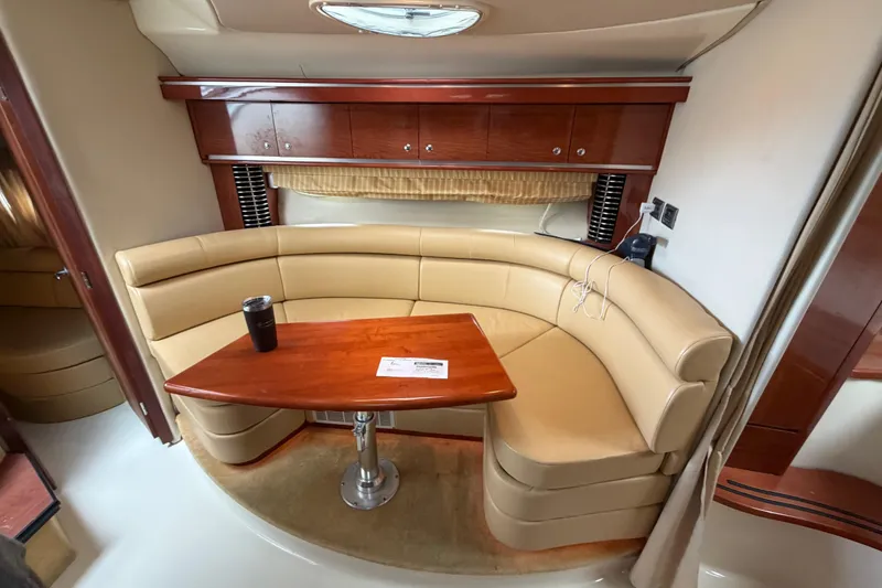 Slide: The Image of Luxurious interior of a 2006 Monterey 350 Sport Yacht with curved seating and wooden table. - 33
