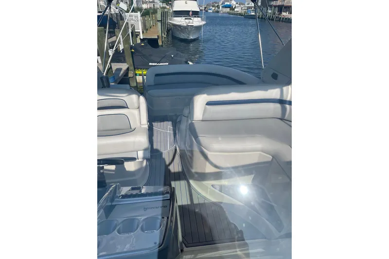 Slide: The Image of 2006 Monterey 350 Sport Yacht interior with plush seating and docked boats in background. - 8