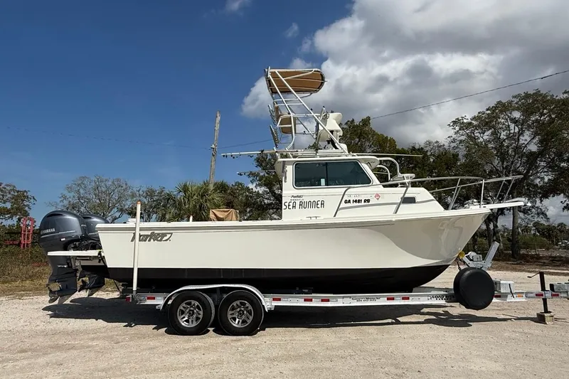 The Image of 2019 Parker 2520 XLD Sport Cabin boat on trailer under blue sky. - 0