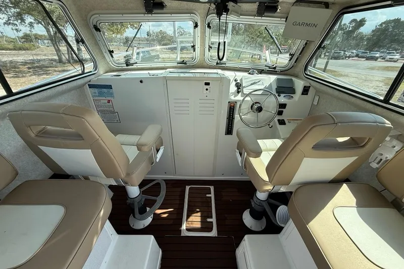 Slide: The Image of 2019 Parker 2520 XLD Sport Cabin interior with steering wheel and beige seating. - 12