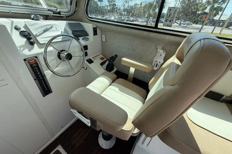 Slide: The Image of 2019 Parker 2520 XLD Sport Cabin interior with steering wheel and beige seating. - 13