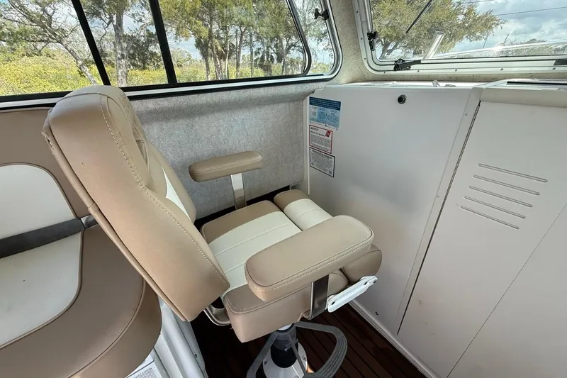 Slide: The Image of Interior of 2019 Parker 2520 XLD Sport Cabin with beige captain's chair and windows. - 14