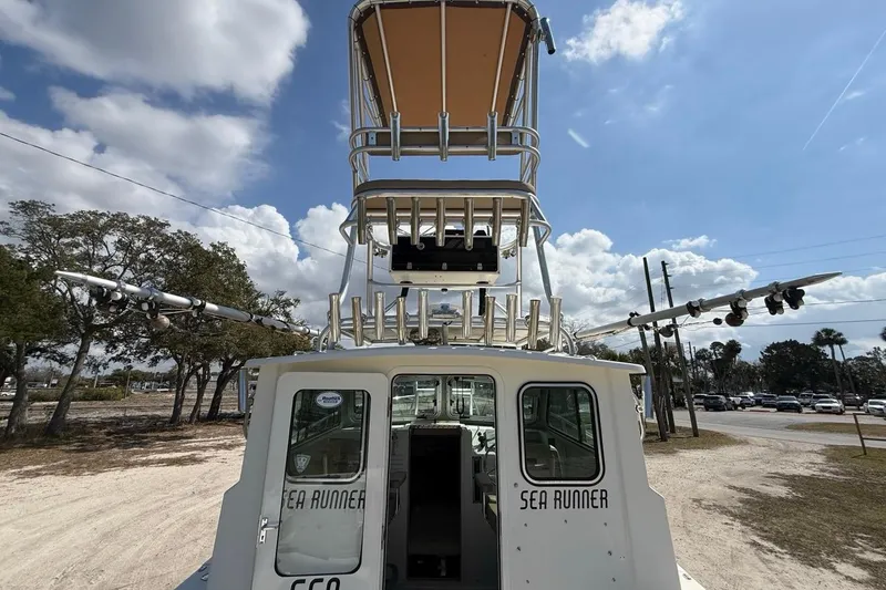 Slide: The Image of 2019 Parker 2520 XLD Sport Cabin boat with tower, parked outdoors under a cloudy sky. - 27