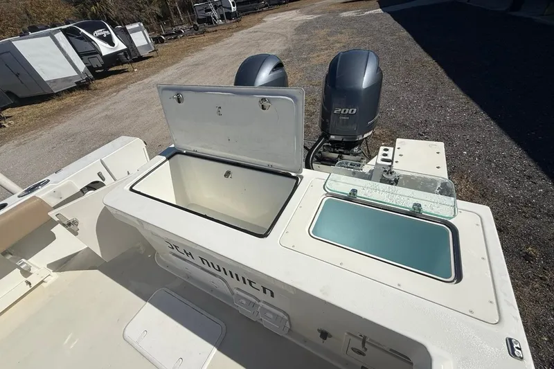 Slide: The Image of 2019 Parker 2520 XLD Sport Cabin boat with open storage compartments and dual outboard engines. - 30