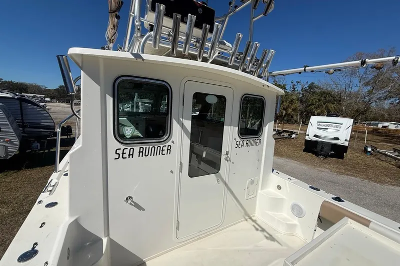 Slide: The Image of 2019 Parker 2520 XLD Sport Cabin boat named "Sea Runner" in a sunny outdoor setting. - 36