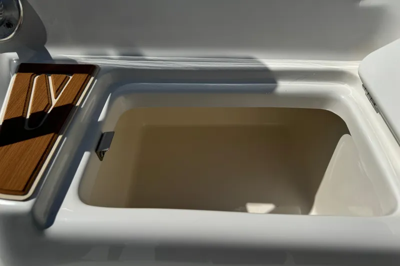Slide: The Image of Open storage compartment on 2025 Key West 219 FS boat, featuring sleek design and wood accent. - 11