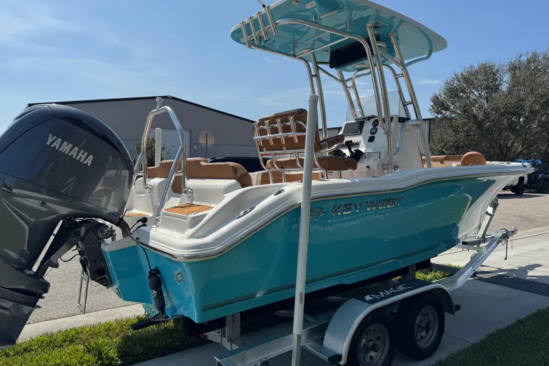 Slide: The Image of 2025 Key West 219 FS boat with Yamaha engine on trailer, parked outdoors. - 15