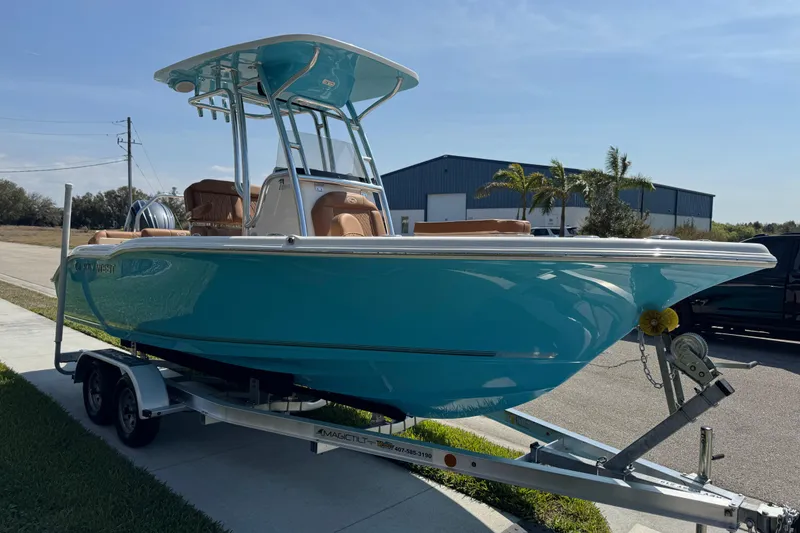 Slide: The Image of 2025 Key West 219 FS boat on trailer, vibrant blue hull, parked outdoors. - 16