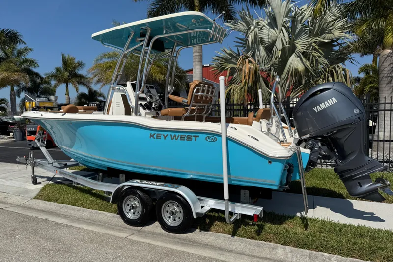 Slide: The Image of 2025 Key West 219 FS boat with Yamaha engine on trailer, surrounded by palm trees. - 3