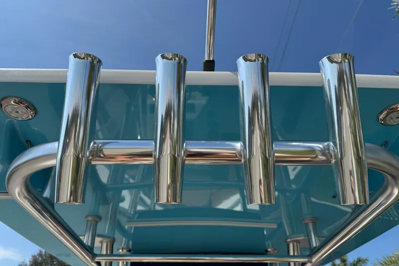 Slide: The Image of 2025 Key West 219 FS boat with stainless steel rod holders under a clear blue sky. - 32