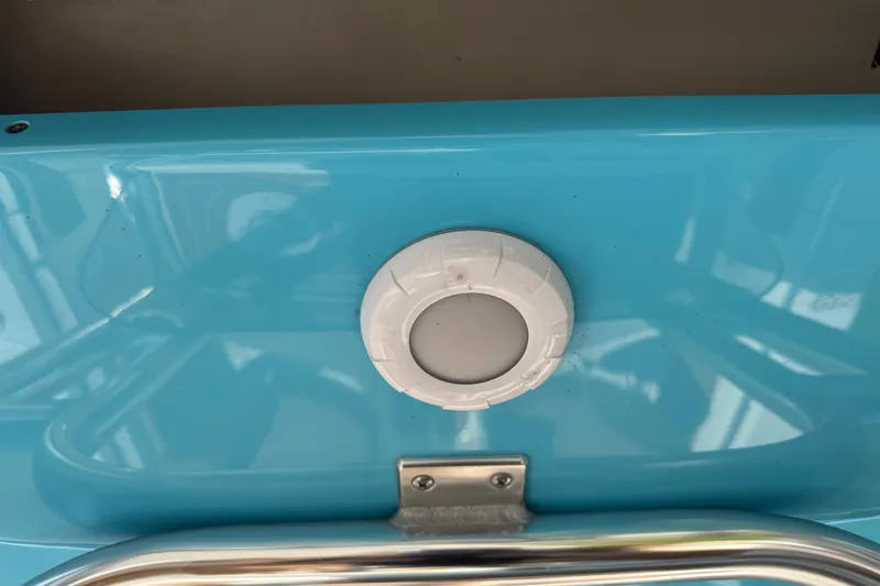 Slide: The Image of Close-up of a 2025 Key West 219 FS boat detail, featuring a blue surface and white fixture. - 45