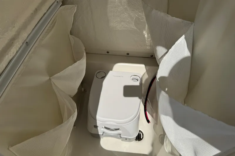 Slide: The Image of Portable toilet inside 2025 Key West 219 FS boat, surrounded by fabric panels. - 49