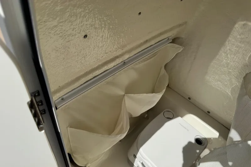 Slide: The Image of 2025 Key West 219 FS boat interior storage compartment with portable toilet. - 51