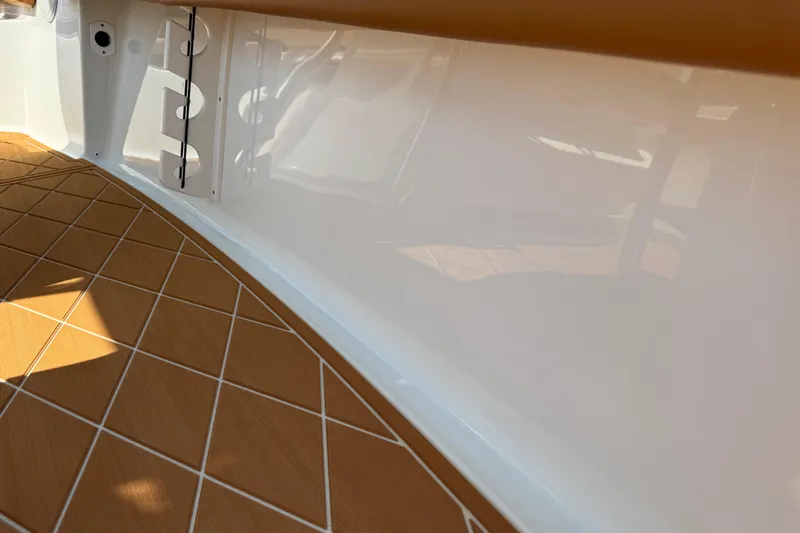 Slide: The Image of 2025 Key West 219 FS boat interior with teak-style flooring and white paneling. - 66