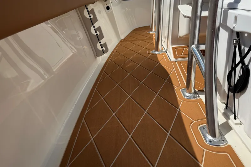 Slide: The Image of 2025 Key West 219 FS boat interior with teak-style flooring and stainless steel railings. - 68