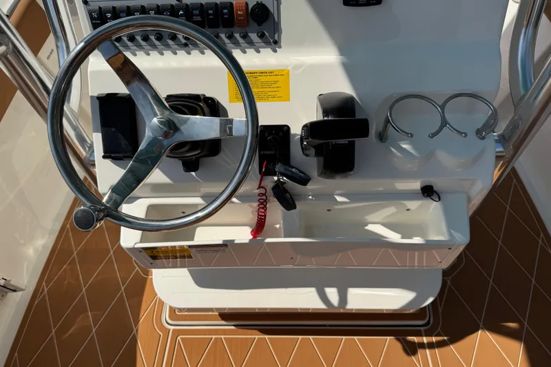 Slide: The Image of 2025 Key West 219 FS boat helm with steering wheel and controls. - 69