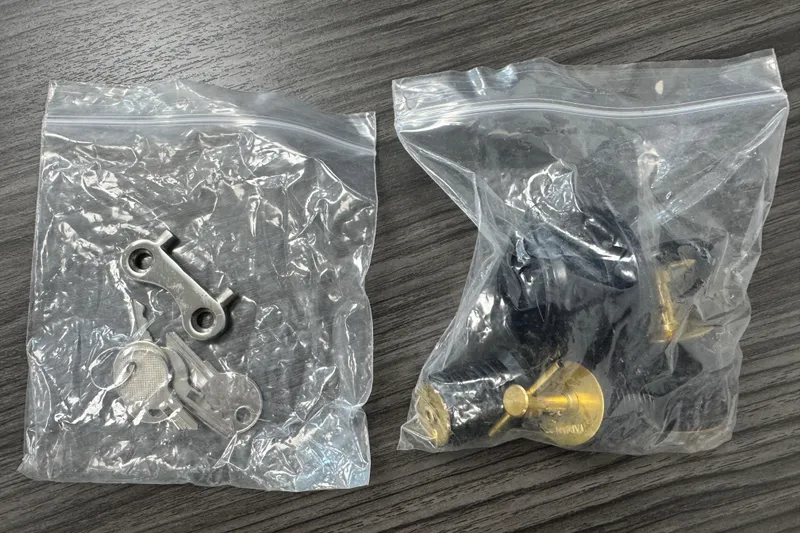 Slide: The Image of Plastic bags containing metal and brass boat parts on a wooden surface. - 71