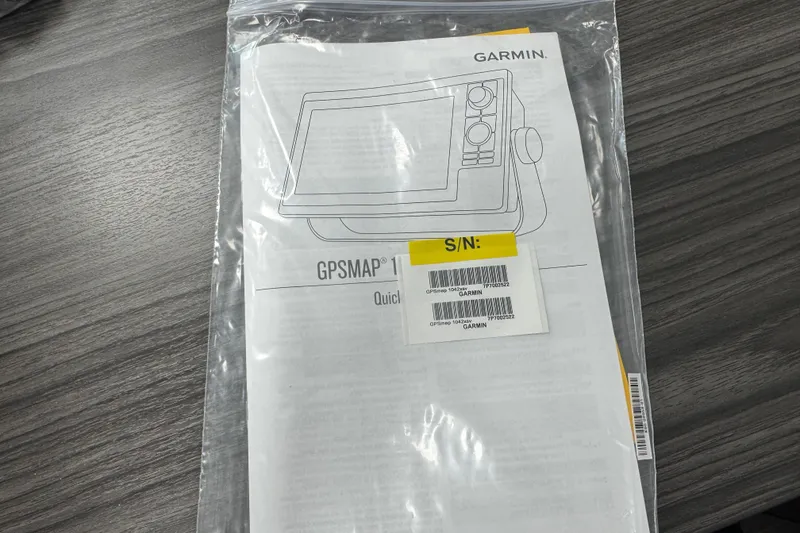 Slide: The Image of Garmin GPSMAP manual in plastic bag on wooden table, related to 2025 Key West 219 FS. - 74