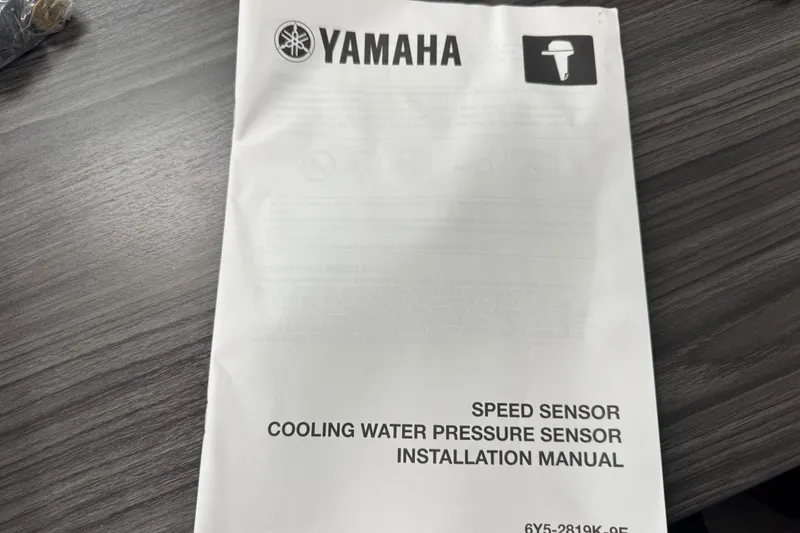 Slide: The Image of Yamaha installation manual for speed and cooling water pressure sensors on a table. - 76