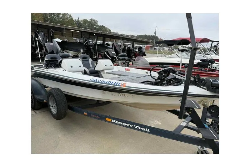The Image of 1996 Ranger 482 V boat on trailer, parked in marina with other boats. - 1