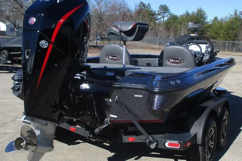Slide: The Image of 2025 Triton 19 TrX Patriot boat with powerful outboard motor, parked on trailer. - 2