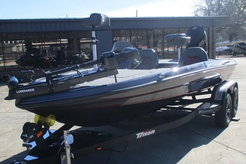 Slide: The Image of 2025 Triton 19 TrX Patriot bass boat on trailer, featuring Lowrance equipment. - 7