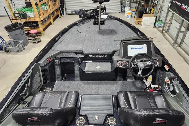 Slide: The Image of 2014 Ranger Z518 Cup-Equipped boat interior with Lowrance system and dual seats in a garage. - 7