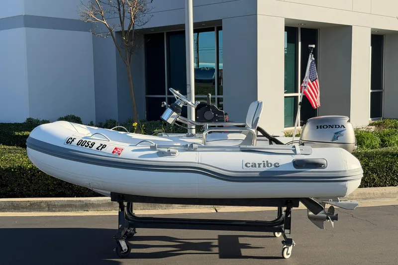 Slide: The Image of 2014 Caribe C10X inflatable boat with Honda outboard motor on display. - 0