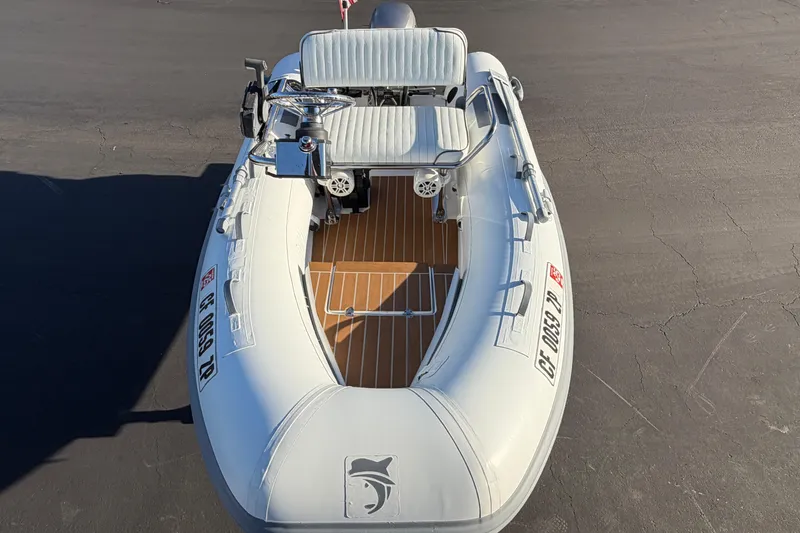 Slide: The Image of Inflatable boat Caribe C10X 2014 with seating and steering console on a paved surface. - 1