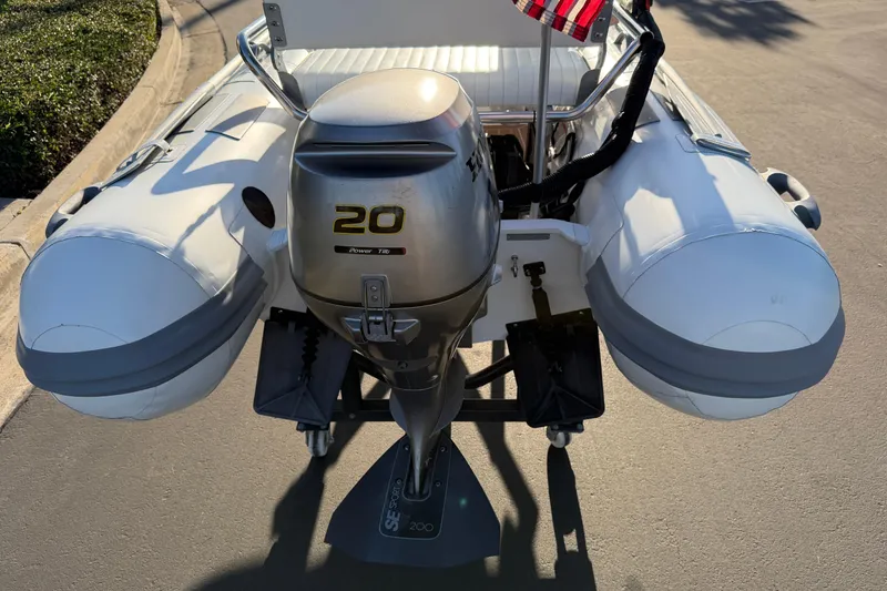 Slide: The Image of Inflatable boat with 20HP outboard motor, Caribe C10X, 2014 model, parked on pavement. - 14