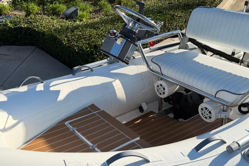 Slide: The Image of White Caribe C10X inflatable boat interior with steering wheel and seating, 2014 model. - 5