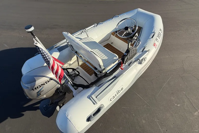 Slide: The Image of Inflatable Caribe C10X boat, 2014 model, with Honda motor and American flag. - 7