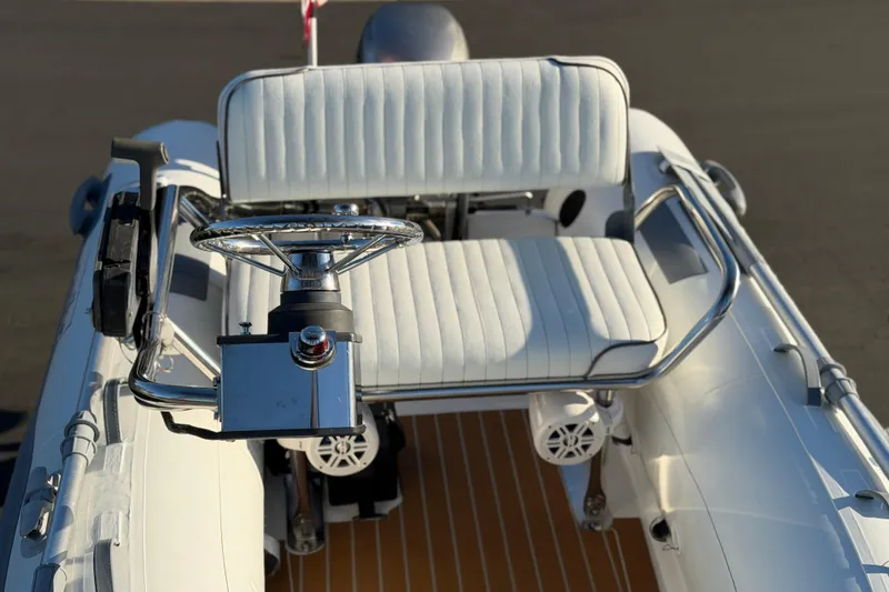 Slide: The Image of 2014 Caribe C10X boat interior with steering wheel and white seating. - 9