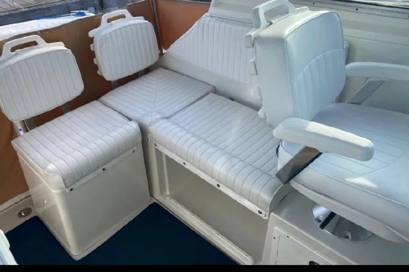 Slide: The Image of 2006 Back Cove 29 boat interior with white cushioned seating and armrests. - 2
